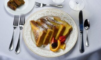 A plate with french toast and fruit on it.